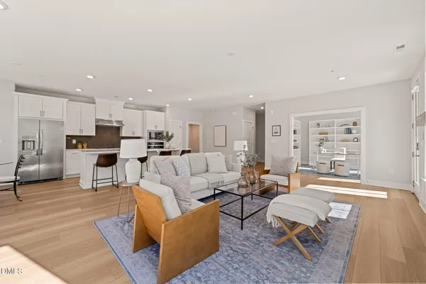 a living room with furniture kitchen view and a table