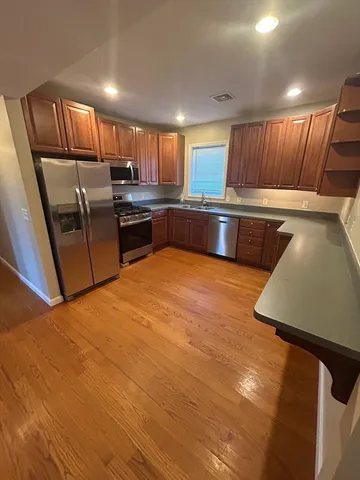 a kitchen with stainless steel appliances kitchen island granite countertop a sink counter space cabinets and stainless steel appliances