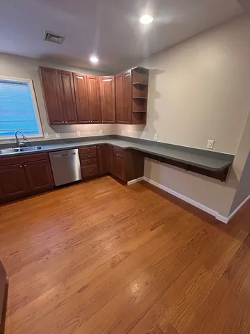 a kitchen with stainless steel appliances wooden cabinets and entryway