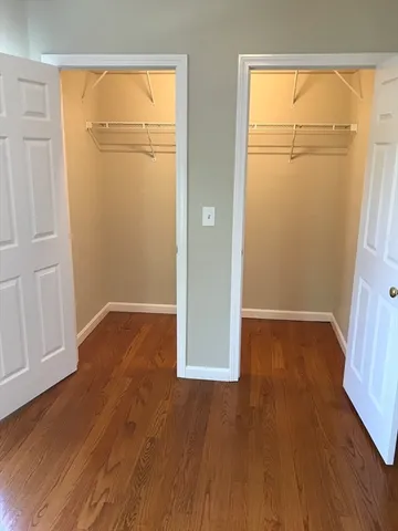 an empty room with wooden floor and cabinet
