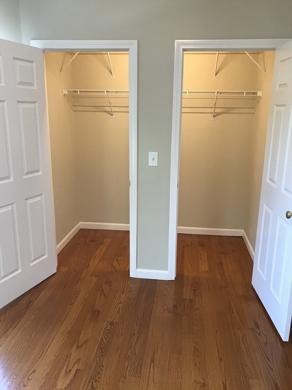 73 Broadway, Unit 3 Quincy, MA 02169 - Photo 8 of 16 an empty room with wooden floor and cabinet