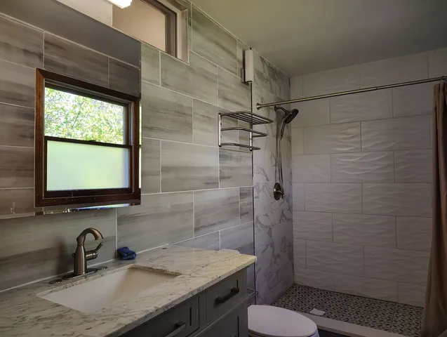 a bathroom with a sink toilet and shower