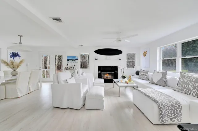 a living room with furniture a fireplace and a large window