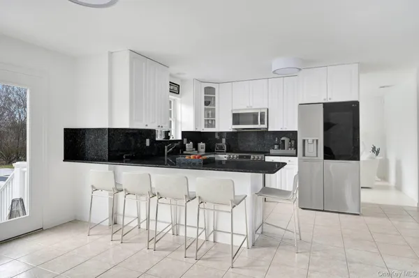 a kitchen with stainless steel appliances a stove a sink a microwave and a refrigerator