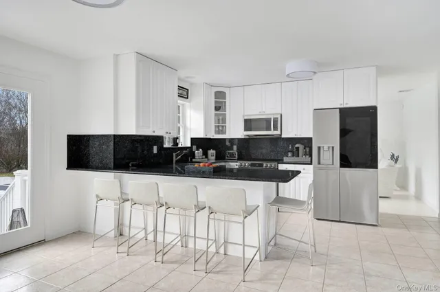 a kitchen with stainless steel appliances a stove a sink a microwave and a refrigerator