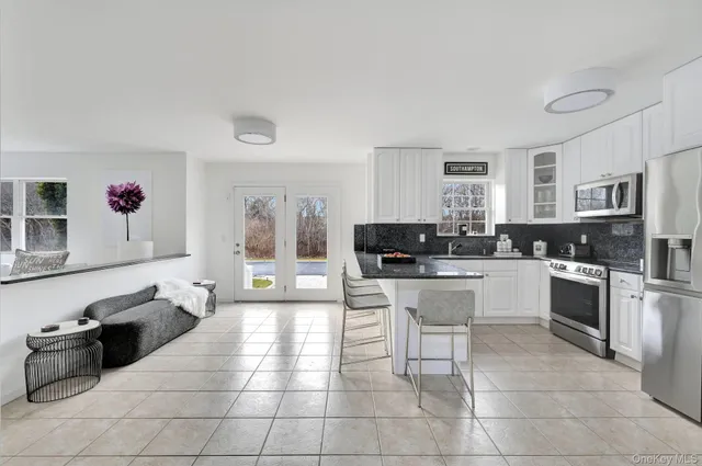 a large white kitchen with cabinets and stainless steel appliances