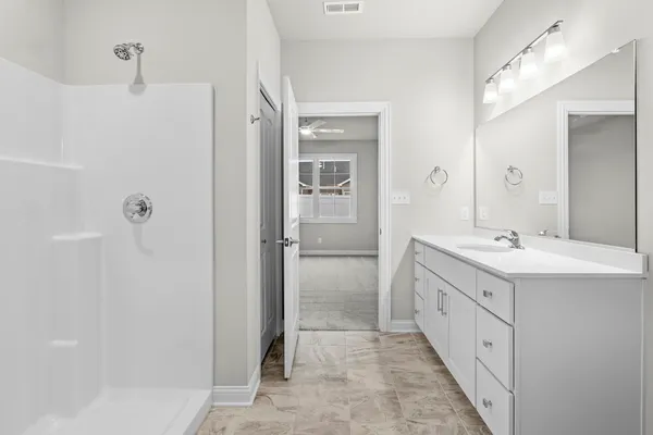 a spacious bathroom with a double vanity sink a large mirror next to a shower