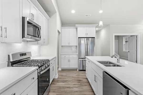 a kitchen with a sink stove and refrigerator