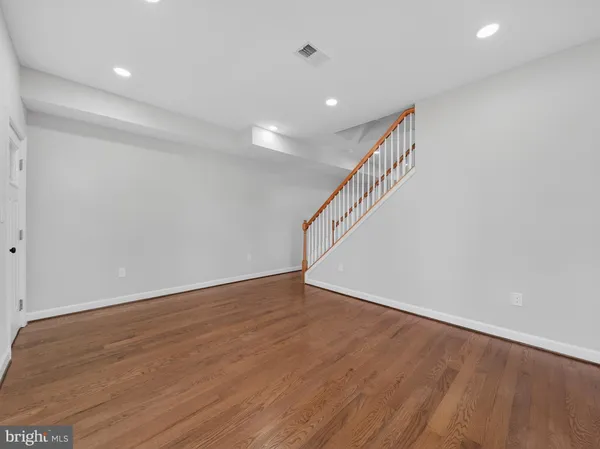 a view of an empty room with wooden floor