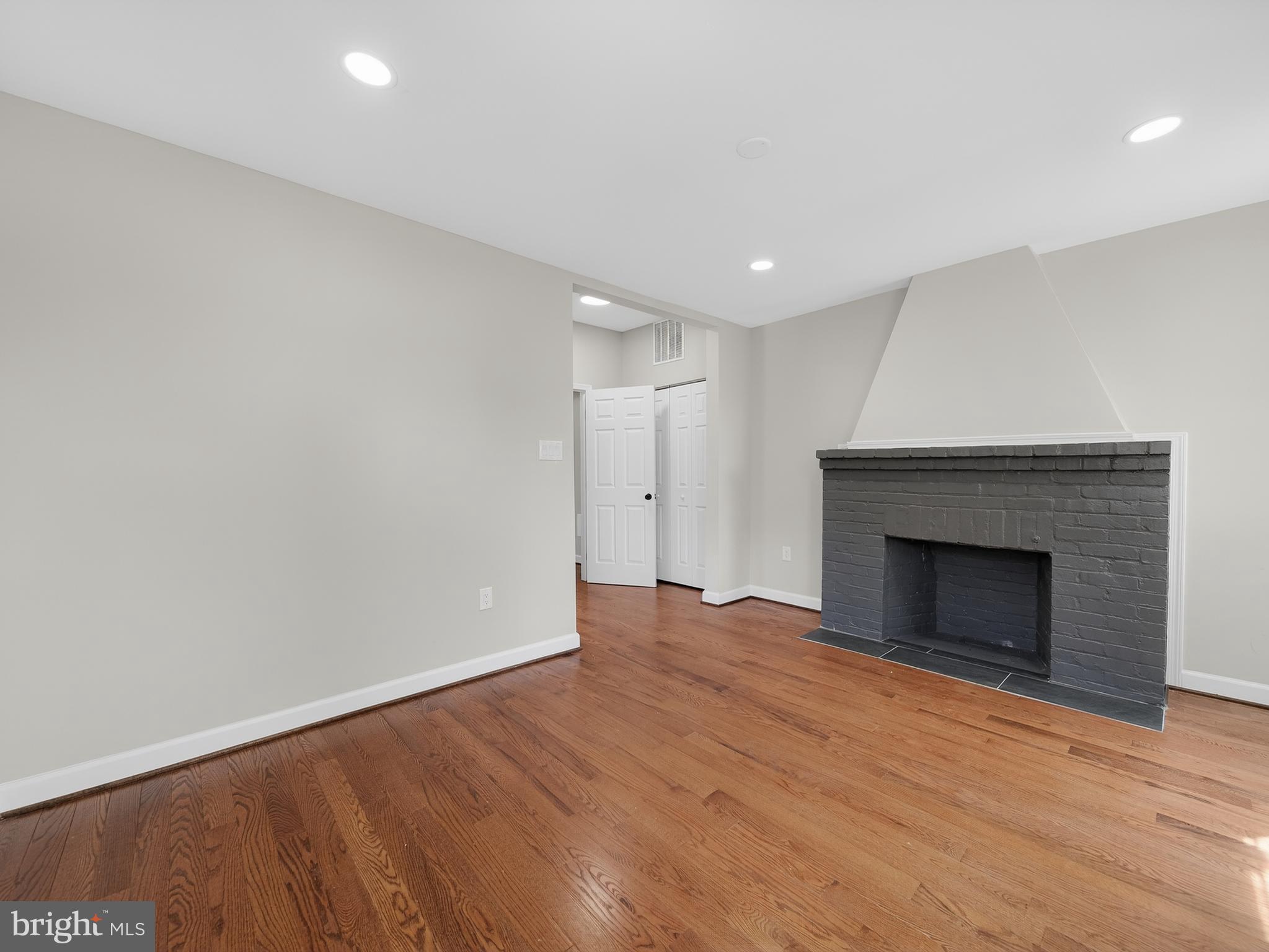 5919 Addison Road Capitol Heights, MD 20743 - Photo 19 of 40 a view of an empty room with wooden floor fireplace and a window
