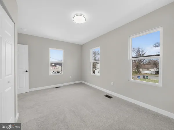 an empty room with windows and closet