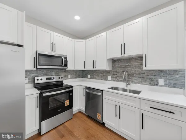 a kitchen with white cabinets stainless steel appliances and sink