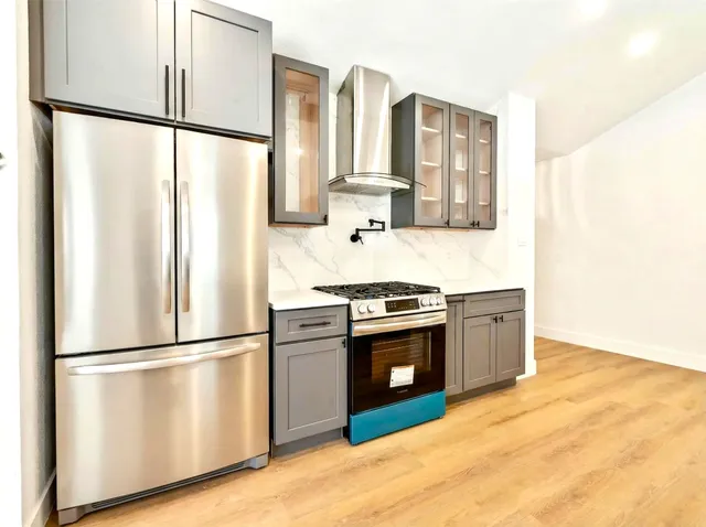 a kitchen with stainless steel appliances granite countertop a refrigerator and a stove