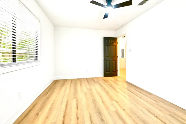 a view of an empty room with wooden floor