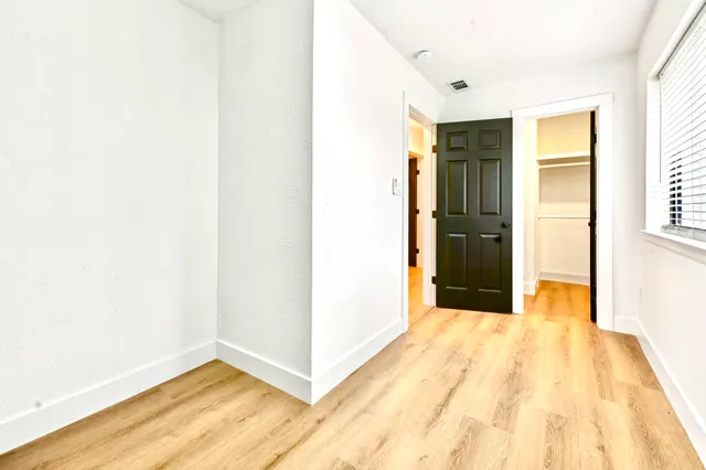 a view of a room with wooden floor and a hallway