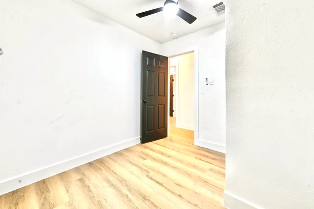 a view of a bedroom with a bed and a ceiling fan