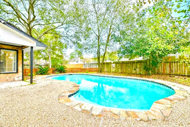 a swimming pool with an outdoor space and seating area