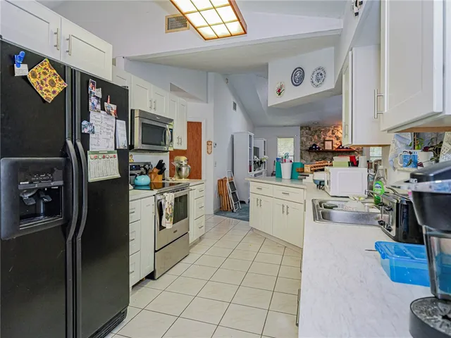 a kitchen with a refrigerator cabinets and wooden floor