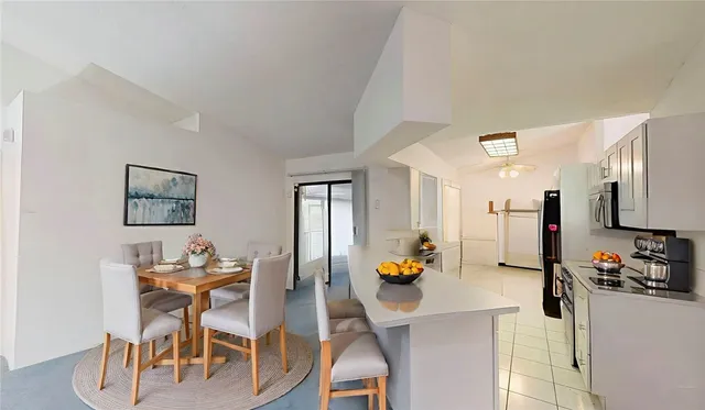a kitchen with stainless steel appliances kitchen island granite countertop a table and chairs in it