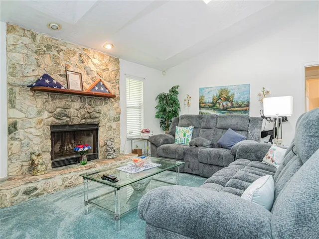 a living room with furniture a fireplace and a large window