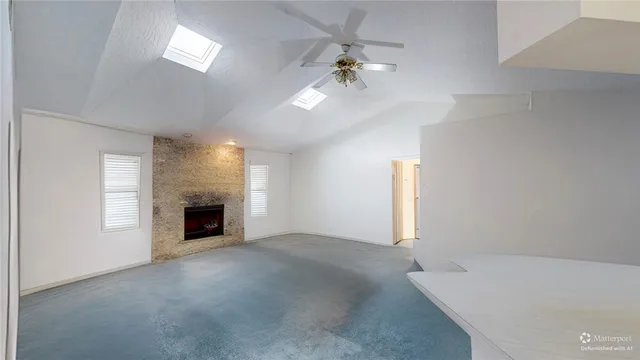 an empty room with windows and fireplace