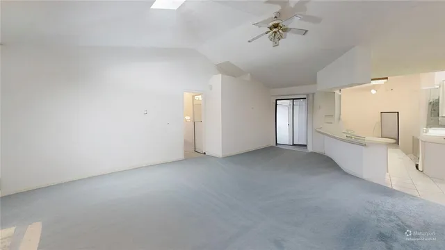 a view of a big room with chandelier fan and windows