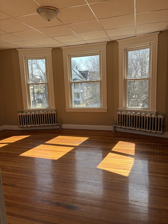 658 Sumner Avenue, Unit 2 Springfield, MA 01108 - Photo 6 of 11 an empty room with wooden floor and windows