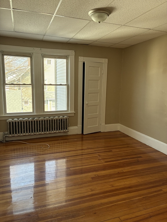 658 Sumner Avenue, Unit 2 Springfield, MA 01108 - Photo 8 of 11 an empty room with wooden floor and windows