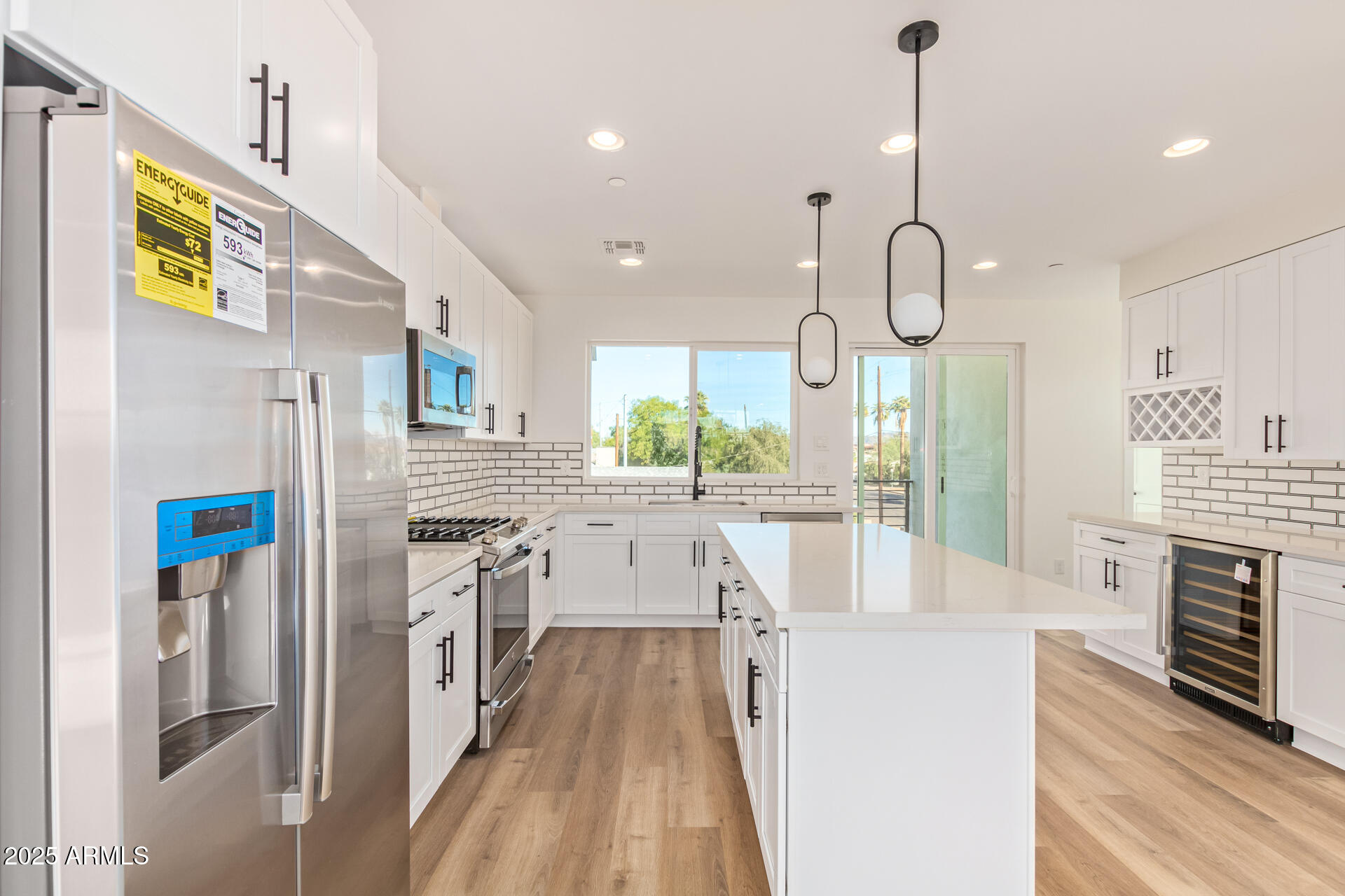 3616 North 12th Street Phoenix, AZ 85014 - Photo 17 of 25 a kitchen with stainless steel appliances kitchen island granite countertop a refrigerator a oven a stove and a wooden floors