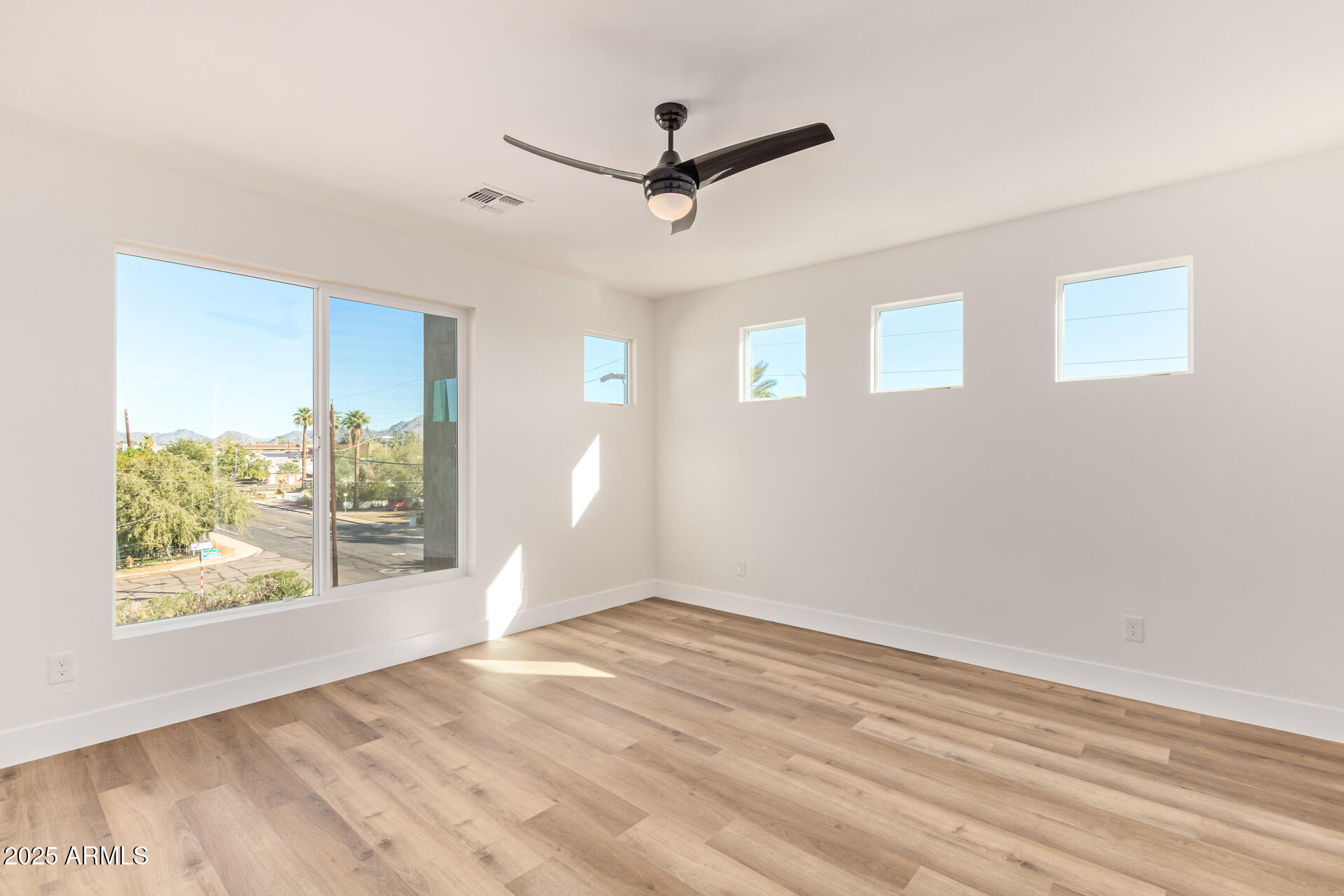 3616 North 12th Street Phoenix, AZ 85014 - Photo 20 of 25 a view of empty room with wooden floor and fan