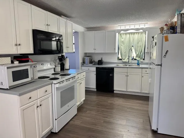 a kitchen with appliances a sink and cabinets