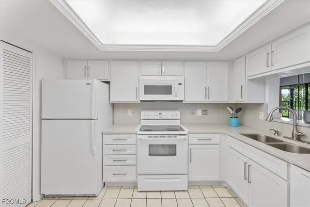 a white refrigerator freezer sitting inside of a kitchen with white cabinets