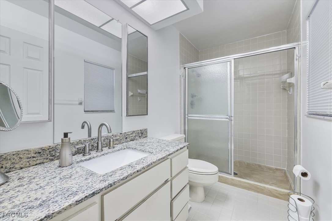 4728 Orange Grove Boulevard, Unit 8 North Fort Myers, FL 33903 - Photo 14 of 31 a bathroom with a granite countertop sink toilet and shower