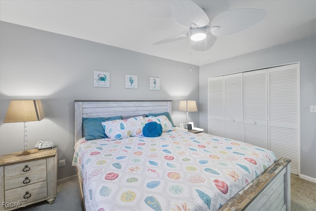 4728 Orange Grove Boulevard, Unit 8 North Fort Myers, FL 33903 - Photo 16 of 31 a bedroom with a large bed and a chandelier