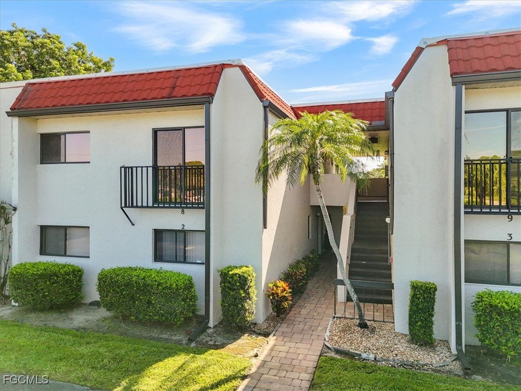 4728 Orange Grove Boulevard, Unit 8 North Fort Myers, FL 33903 - Photo 23 of 31 a front view of a house with garden