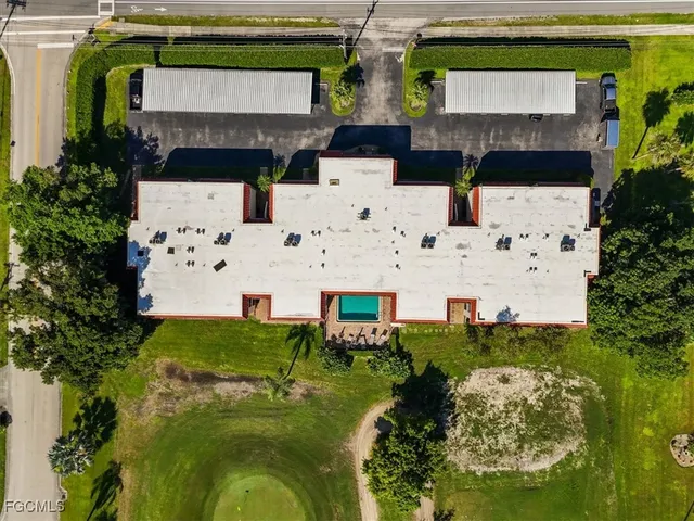an aerial view of residential houses with outdoor space and parking