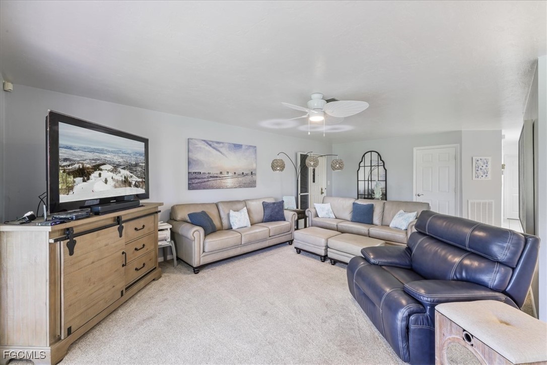 4728 Orange Grove Boulevard, Unit 8 North Fort Myers, FL 33903 - Photo 4 of 31 a living room with furniture and a flat screen tv