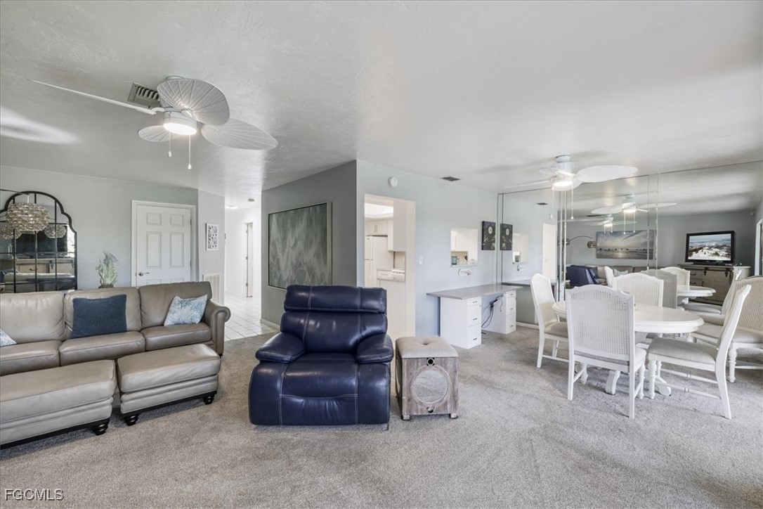 4728 Orange Grove Boulevard, Unit 8 North Fort Myers, FL 33903 - Photo 5 of 31 a living room with furniture and a chandelier