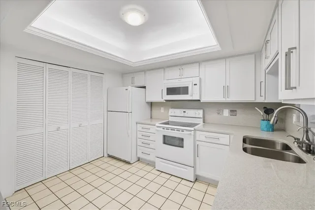 a kitchen with white cabinets and white appliances