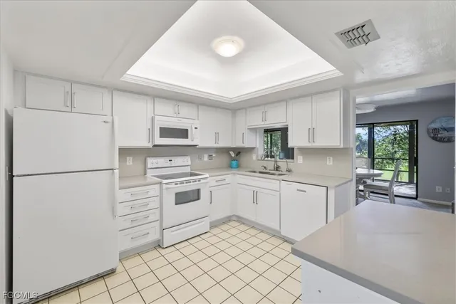 a kitchen with white cabinets and white appliances