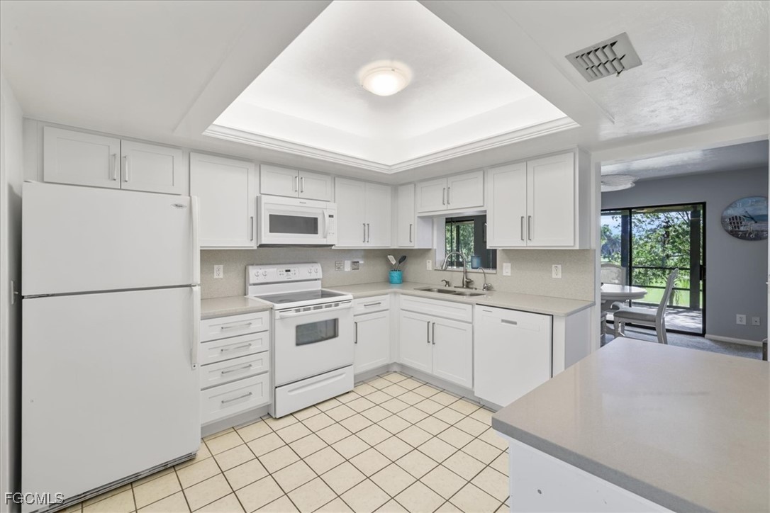 4728 Orange Grove Boulevard, Unit 8 North Fort Myers, FL 33903 - Photo 10 of 31 a kitchen with white cabinets and white appliances