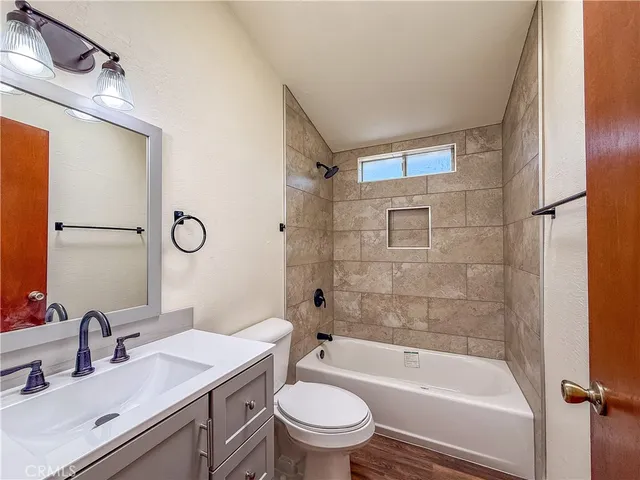 a bathroom with a granite countertop sink a toilet and shower