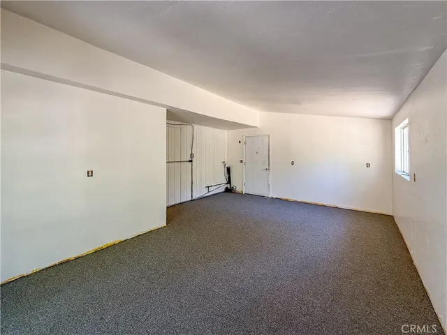 a view of a white house with a large tree