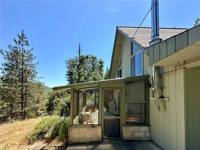 a front view of a house with a yard and tree