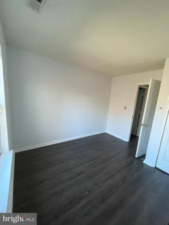 an empty room with wooden floor and stairs