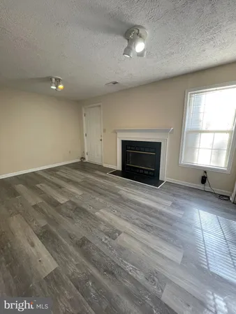 an empty room with windows and fireplace