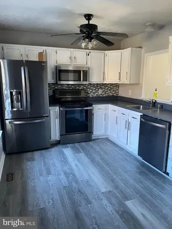 a kitchen with stainless steel appliances a stove a refrigerator and a sink