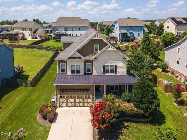 a front view of a house with a yard and potted plants