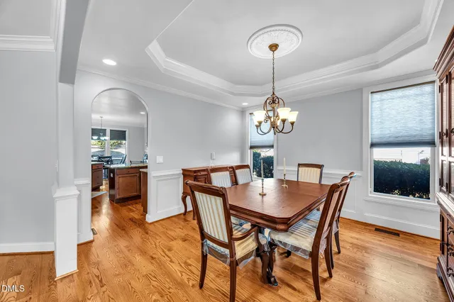 a dining room with furniture a chandelier and wooden floor