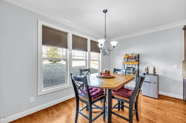 a view of a dining room and livingroom with furniture wooden floor a chandelier